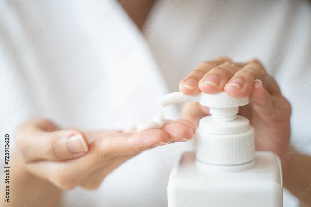 Body skin care routine concept. Close-up view hands of a young woman applying lotion cream on the shoulder Body skin care routine concept. Close-up view hands of a young woman applying lotion cream on the shoulder