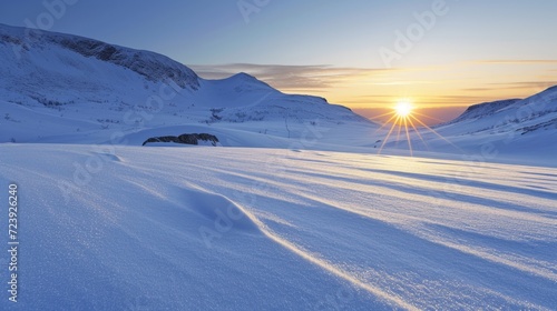 A winter wonderland of snow-covered mountains and a setting sun