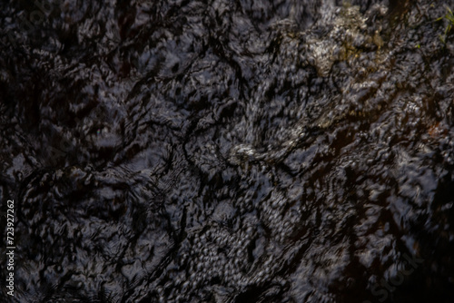  background of a dark water surface with ripples and waves. The surface of the water in the autumn forest. Abstract background. texture of a dark autumn water in the river