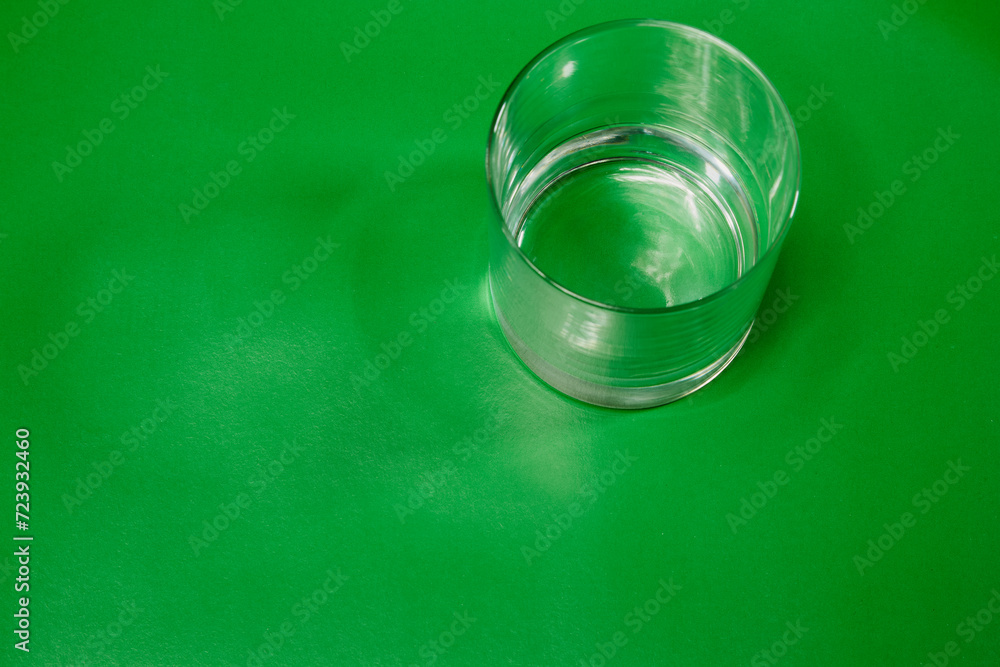 A clean empty glass on a green cloth in close-up. Loneliness and alcohol, alcohol addiction A clean empty glass on a green cloth in close-up. Loneliness and alcohol, alcohol addiction