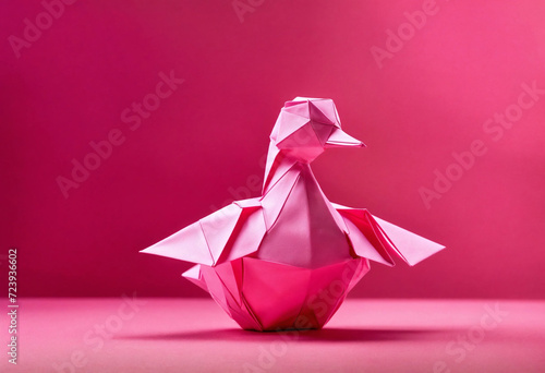 Origami duck on a plain pink background