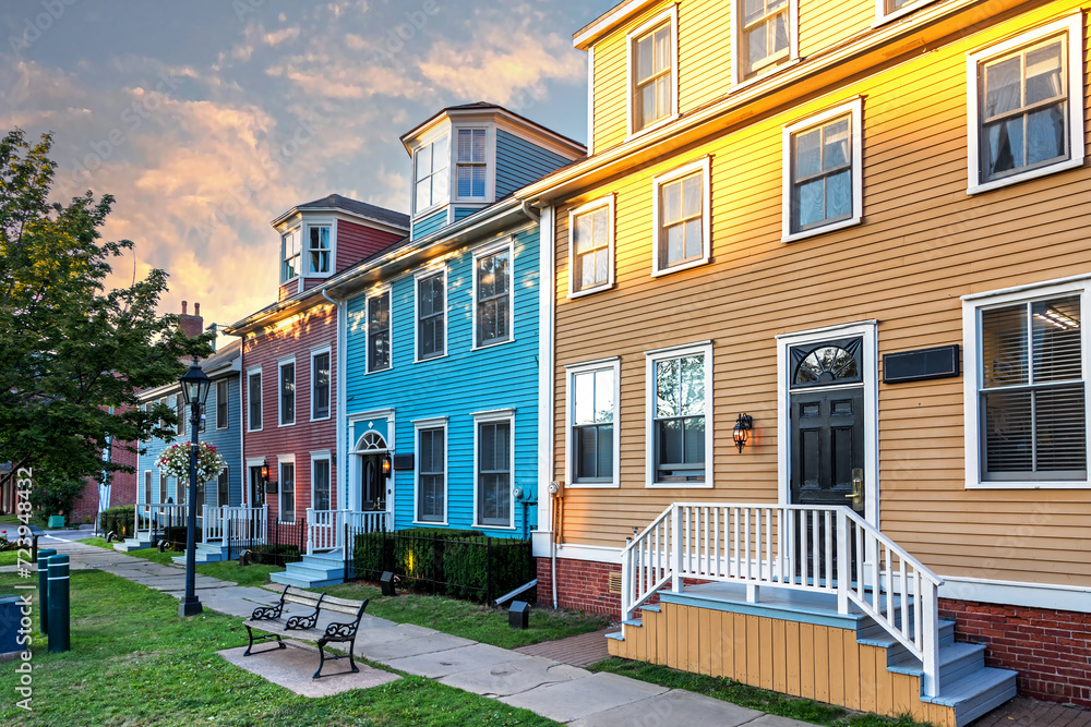The sun sets on a row of the colorful Victorian clapboard houses in Charlottetown, capital of Prince Edward Island, Canada - obrazy, fototapety, plakaty 
