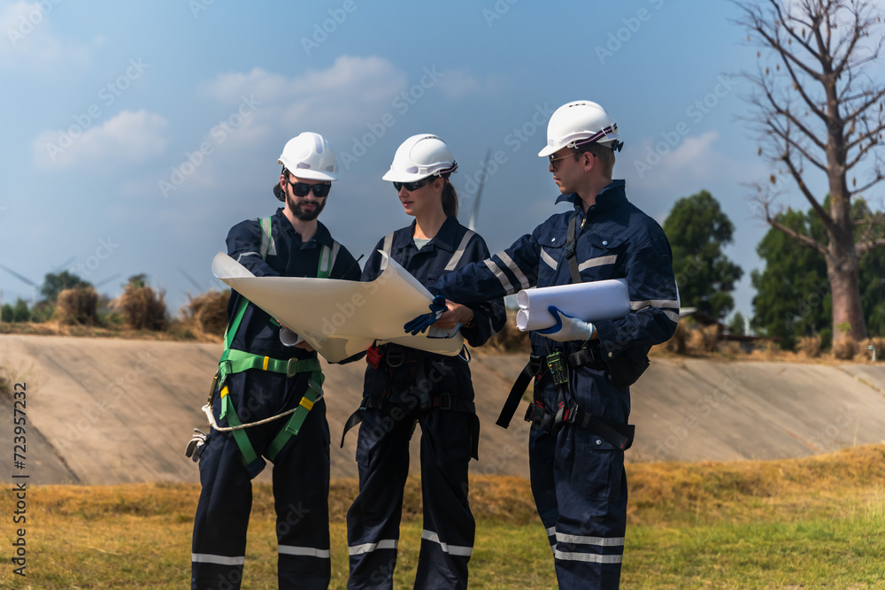 Wind Turbine engineer men and woman team discussing on paperwork in windmill field Wind Turbine engineer men and woman team discussing on paperwork in windmill field