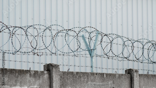 barbed wire and fence on a background of a gray wall photo