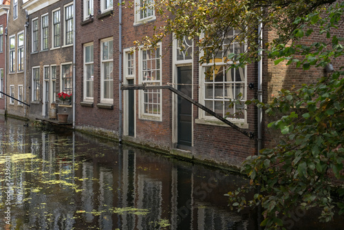 Voldersgracht canal with its typical buildings reflected on the water in the old town of the beautiful city of Delft, Netherlands, in a sunny day. © JoseLuis