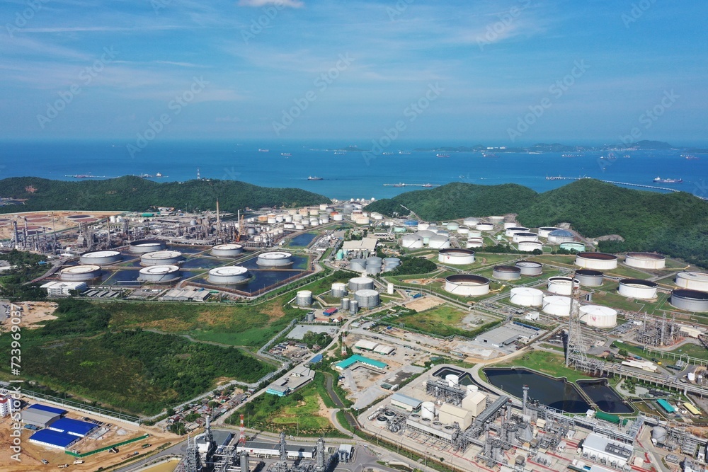 Aerial view of oil refinery or chemical factory and power plant with many storage tanks and pipelines. Business and petrochemical plants, oil storage tanks and for energy and steel pipes.