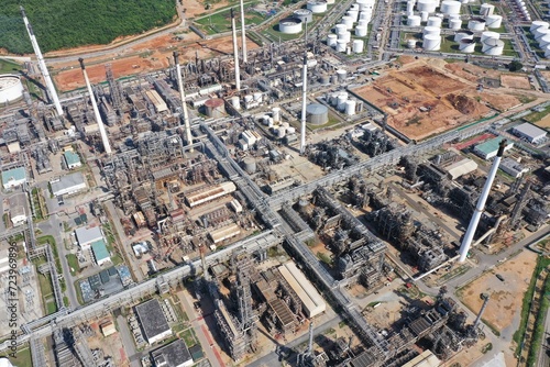 Aerial view of oil refinery or chemical factory and power plant with many storage tanks and pipelines. Business and petrochemical plants, oil storage tanks and for energy and steel pipes. © unikyluckk