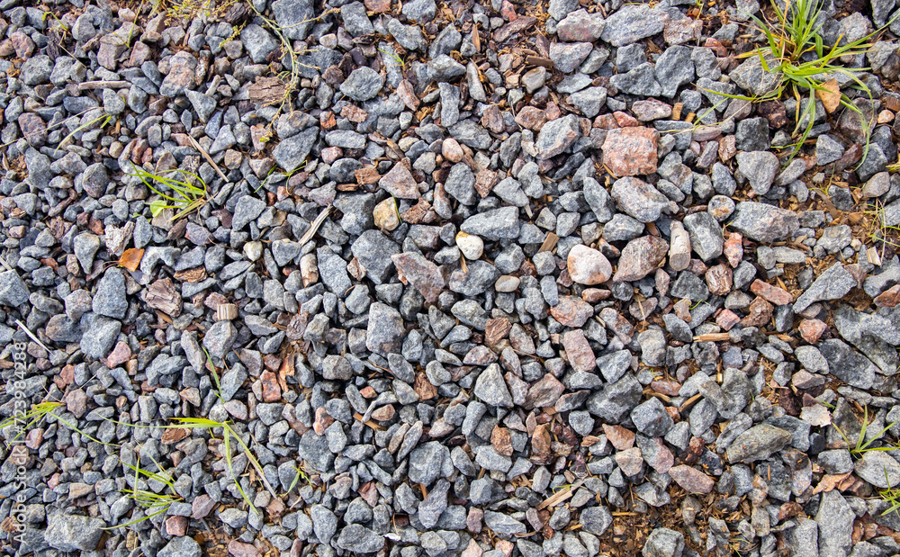 Gravel on the ground as a background. Texture, pattern. Stone pebbles on the ground as a background. Crushed granite stones on the ground Gravel on the ground as a background. Texture, pattern. Stone pebbles on the ground as a background. Crushed granite stones on the ground