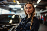 A professional woman mechanic with a braid stands proudly in a garage, with a car hood open in the background