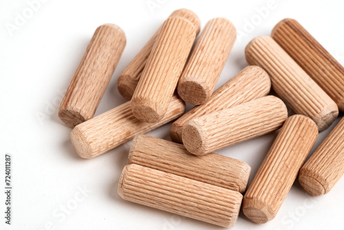 Pile of wooden dowels on the white background. photo