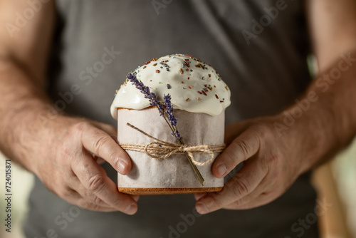 traditional Orthodox Easter cake, in men's hands, close-up on a dark background. happy Easter