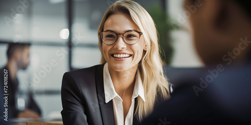 Portrait of attractive blondie haired female entrepreneur smiling to her colleague on office indoor background. Confident businesswoman. Web banner template.