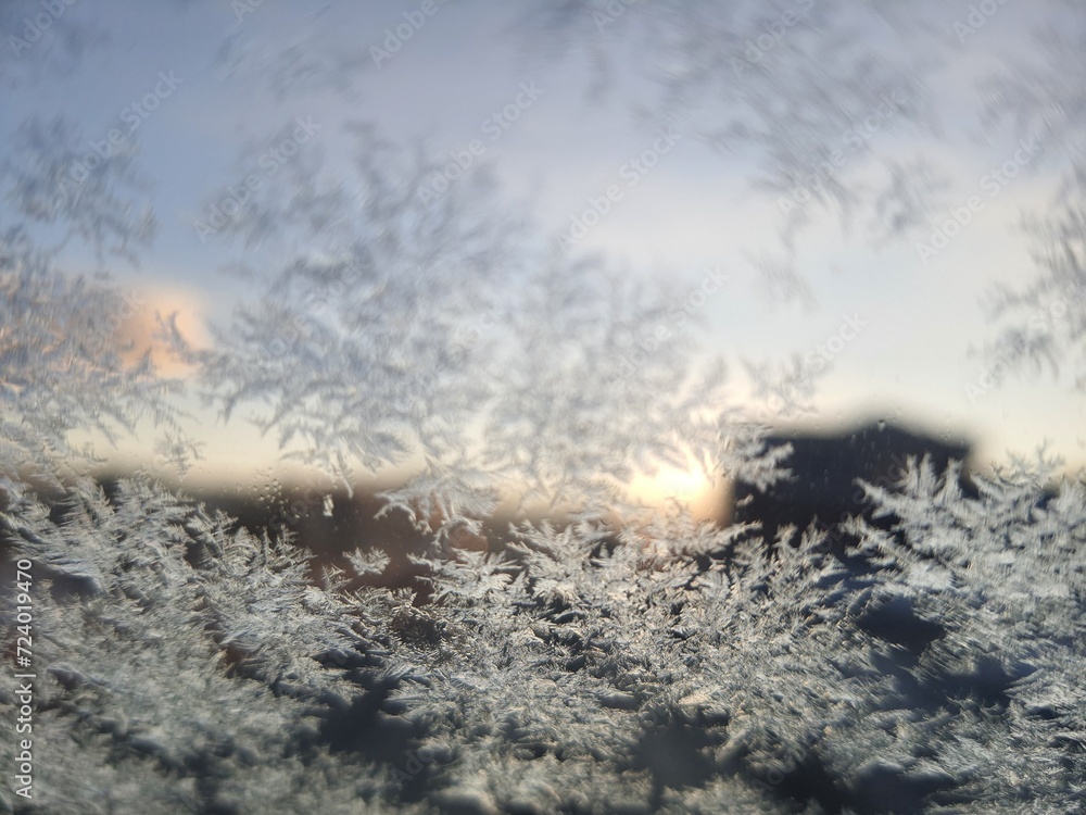 Ice crystals formations on glass car window.