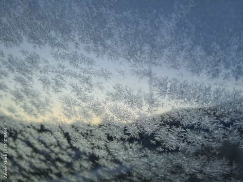 Ice crystals formations on glass car window.