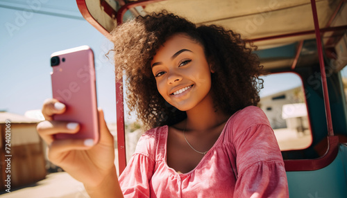 young woman taking a selfie on her mobile. looking at viewer.  photo