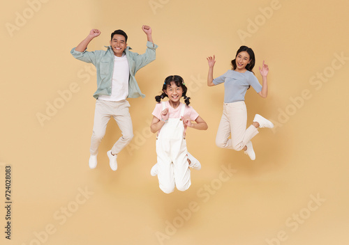 Portrait asian family fun jumping together isolated on nude color studio background.