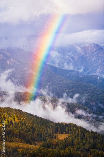 Dolomites Mountains forest and rainbow in autumn season. Italy