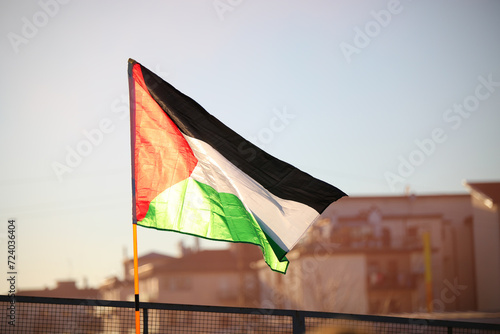 Palestinian flag flying freely in the suburban suburbs backlit at sunset photo