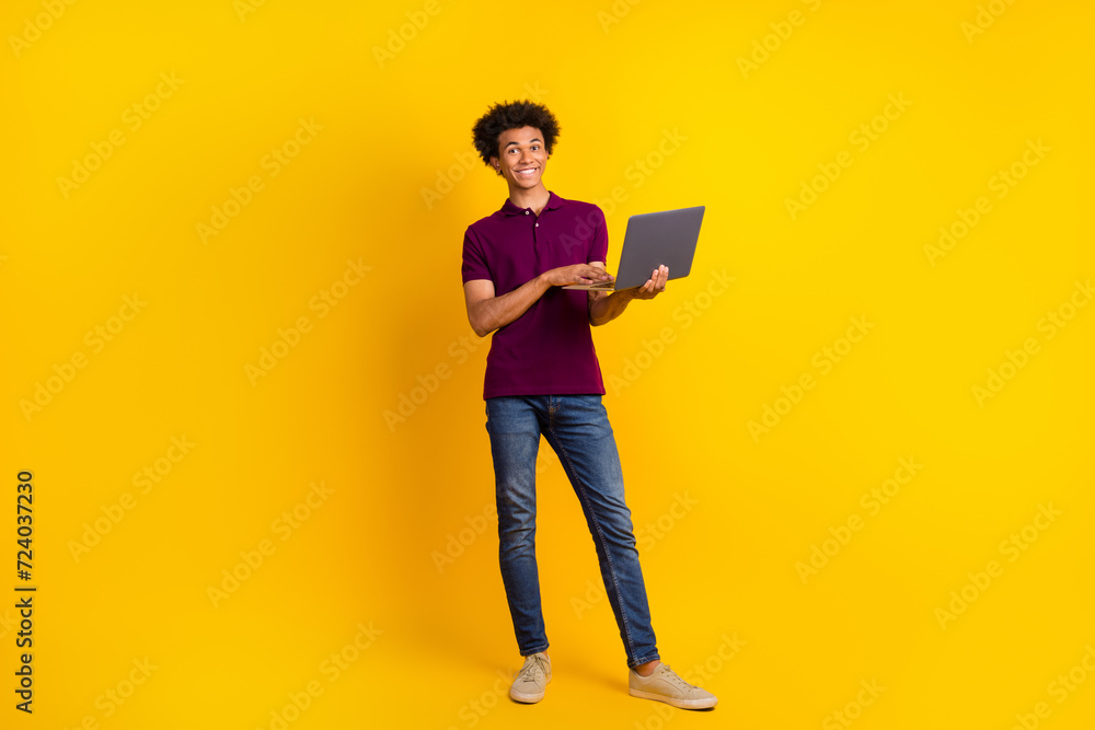 Full length photo of attractive nice man wear trendy clothes hold use wireless modern netbook gadget isolated on yellow color background