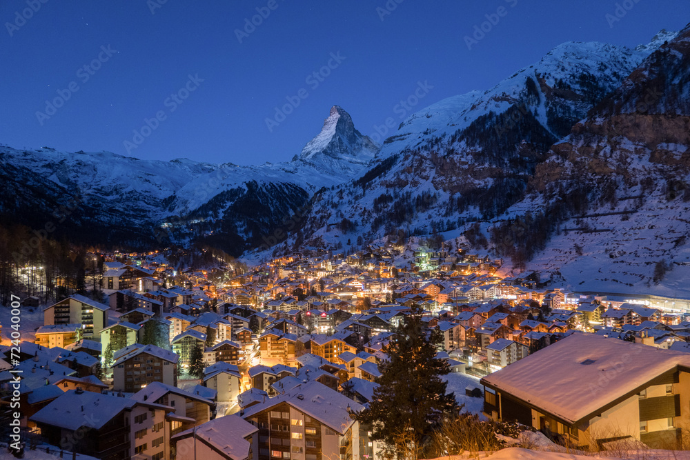 Panoramic landscape of Zermatt city Valley famous travel ski resort and iconic Matterhorn peak at dawn in the swiss alps, Switzerland. The snow covered village and church in Canton Valais in winter.