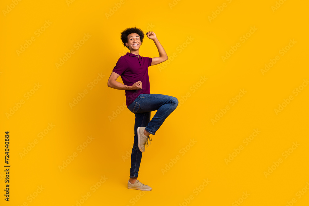Photo of funky cheerful glad guy wear violet stylish clothes raised hands yes win lottery jackpot isolated on yellow color background
