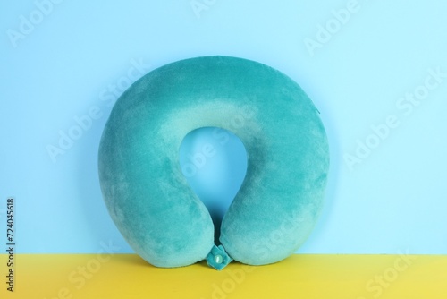 Soft turquoise travel pillow on color background