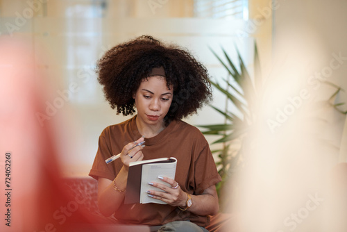 Portrait of woman writing plans and ideas in notebook