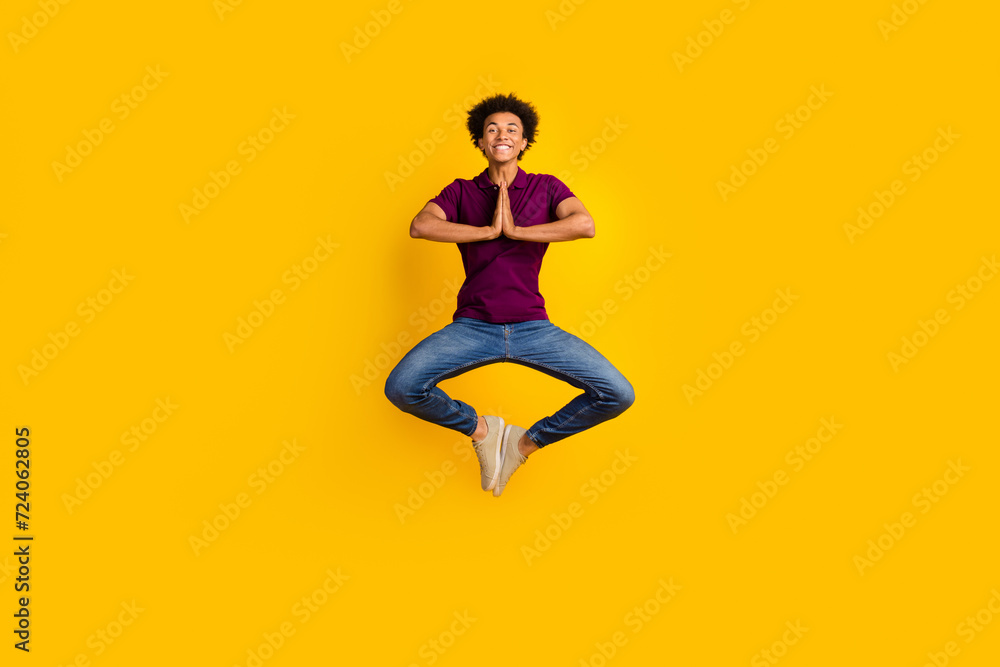 Full length photo of concentrated focused guy wear stylish violet polo meditate pray two hands touch isolated on yellow color background