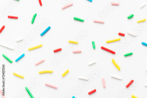flat lay of colorful sprinkles over white background, festive decoration for banner, poster, flyer, card, postcard, cover, brochure, designers
