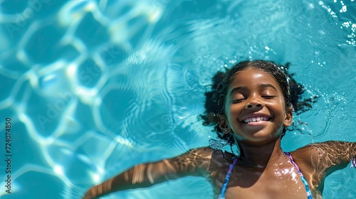 A smiling girl is enjoying herself in the pool. A joyful girl is swimming in the pool. Close-up.