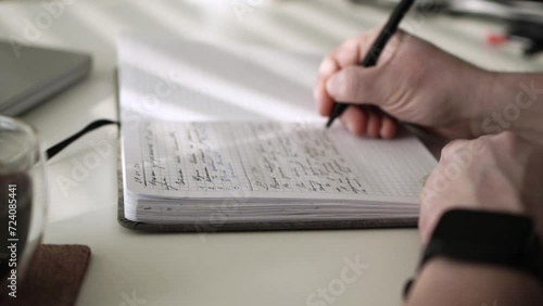 Man journaling thoughts into notebook photo