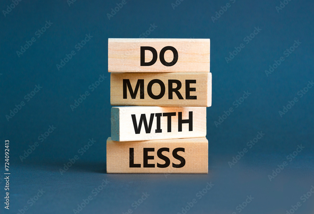 Do more with less symbol. Concept word Do more with less on beautiful wooden block. Beautiful grey table grey background. Business do more with less concept. Copy space.