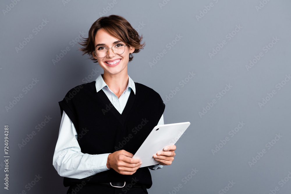 Photo of positive adorable successful lady economist wear trendy clothes presents empty space isolated on gray color background Photo of positive adorable successful lady economist wear trendy clothes presents empty space isolated on gray color background