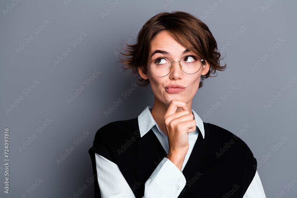 Photo of doubtful unsure woman lawyer wear black waistcoat spectacles hand arm chin looking empty space isolated grey color background Photo of doubtful unsure woman lawyer wear black waistcoat spectacles hand arm chin looking empty space isolated grey color background