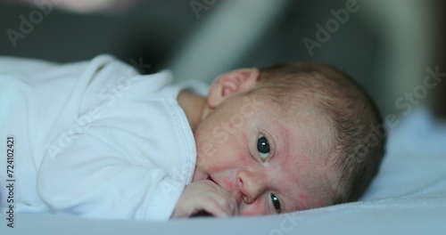 Adorable newborn baby infant smiling feeling happy discovering the world