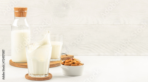 Glass of almond milk splash on white background, Long banner format. copy space for text