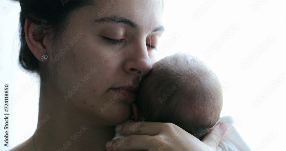 Fototapeta premium Mom holding newborn baby son in her arms, real life and candid family moment