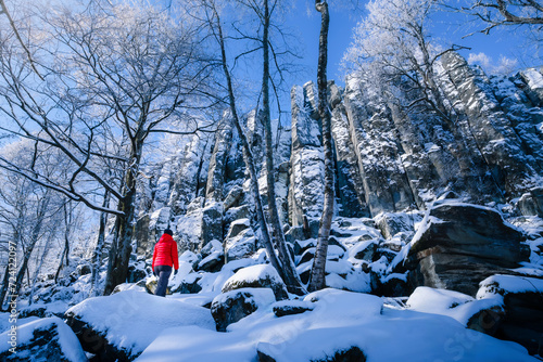 Frau mit roter Jacke im Winter vor Bergmassiv