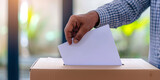 Hand of Latin American person placing his vote in ballot box