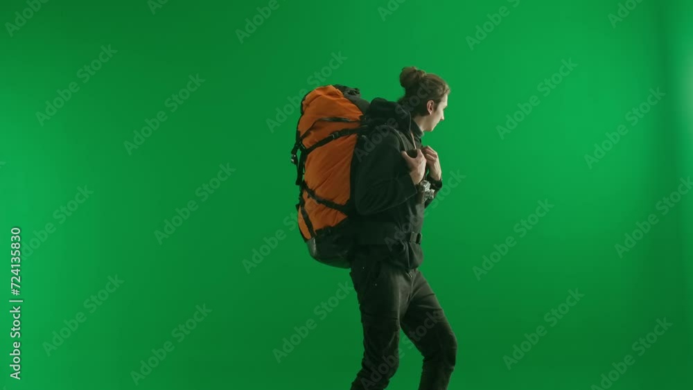 A male traveler with a backpack on his back and a retro camera around his neck climbs up on a green screen close up. After reaching the top, the happy man takes photos with the retro camera. A male traveler with a backpack on his back and a retro camera around his neck climbs up on a green screen close up. After reaching the top, the happy man takes photos with the retro camera.