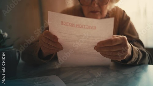 Old woman opening eviction notice letter, shocked with news, financial crisis photo