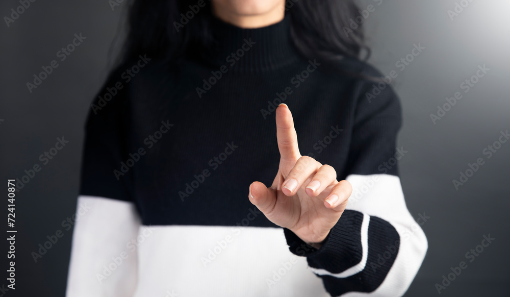 Fototapeta premium a woman in a black and white sweater pointing at something