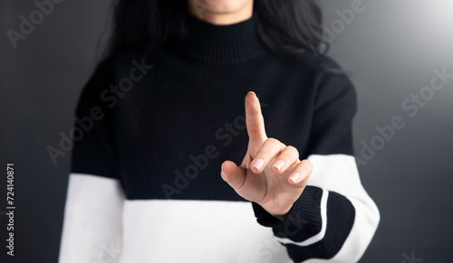 Canvastavla a woman in a black and white sweater pointing at something