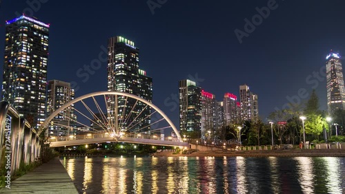 Skyscraper building with bridge illumination on songdo river in central park at Incheon, South Korea photo