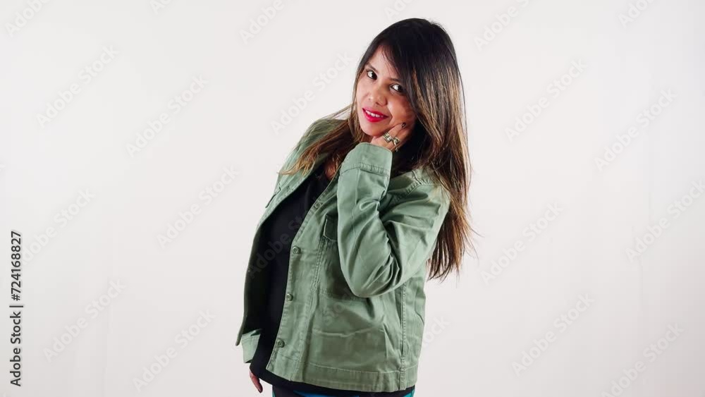 smiling young woman in casual attire posing against a white background playfully flipping her hair smiling young woman in casual attire posing against a white background playfully flipping her hair