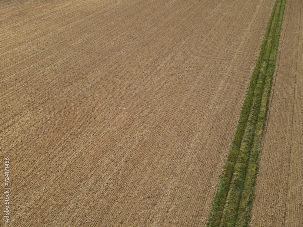 Aerial view of plowed farm field with brown soil Aerial view of plowed farm field with brown soil