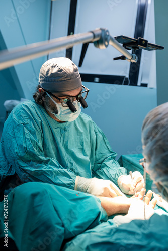  Skilled surgeon performs a precise operation in a sterile operating room.