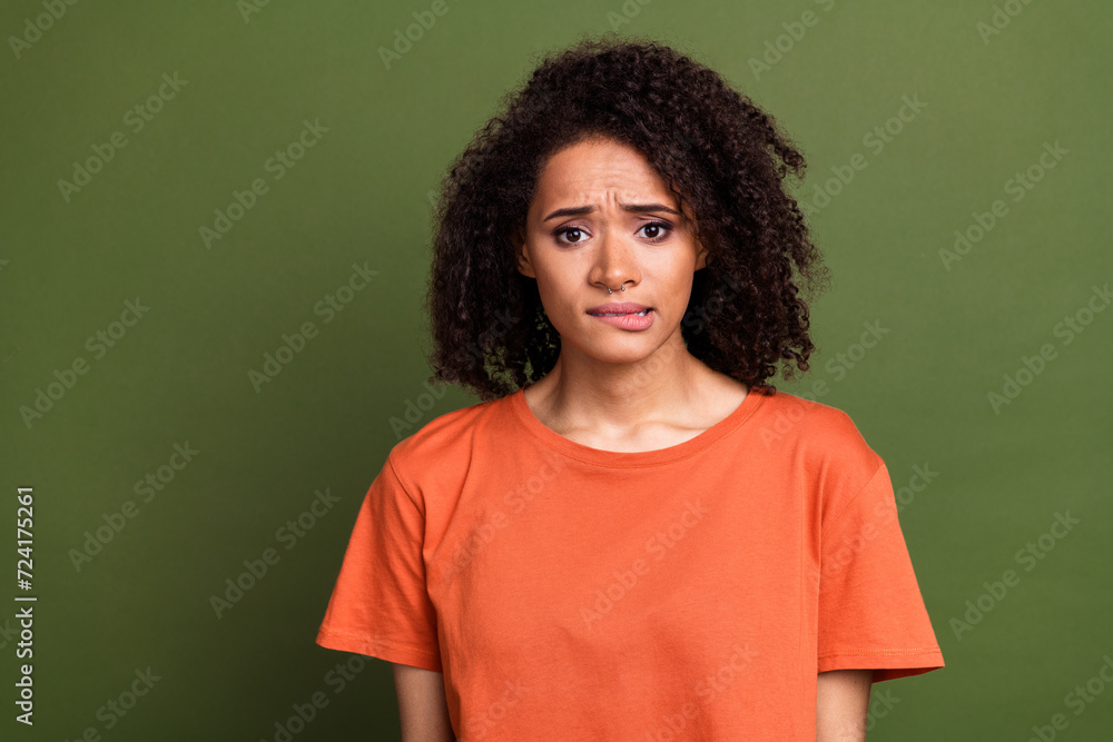 Photo portrait of attractive young woman nervous bite lips worried wear trendy orange clothes isolated on khaki color background Photo portrait of attractive young woman nervous bite lips worried wear trendy orange clothes isolated on khaki color background
