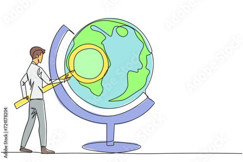 Single continuous line drawing young businessman stood holding the magnifier and inspected the globe. Map out good territory to create and develop new ventures. One line design vector illustration