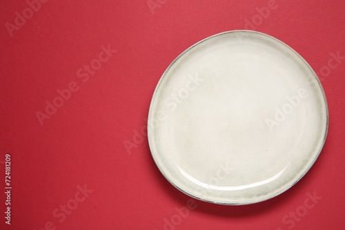One ceramic plate on red background, top view. Space for text